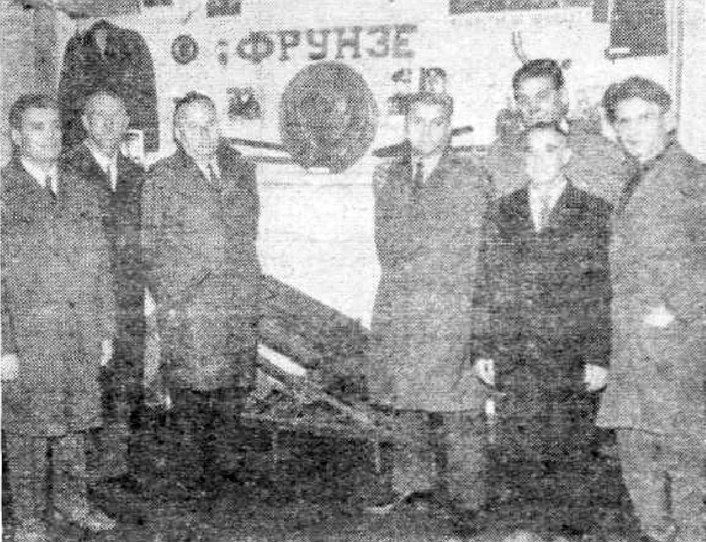 Стоит группа людей. В центре кормовой герб монитора УДАРНЫЙ и надпись ФРУНЗЕ с кормы одноименного эсминца